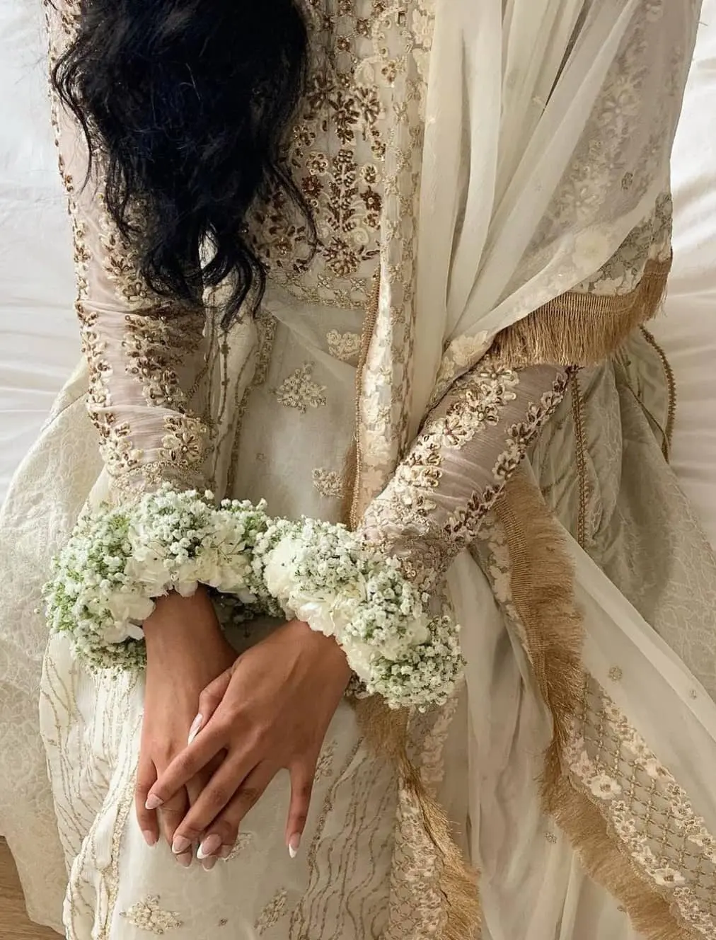 Pakistani Indian bride wearing custom fresh flower jewelry and gajra headpiece for traditional wedding ceremony